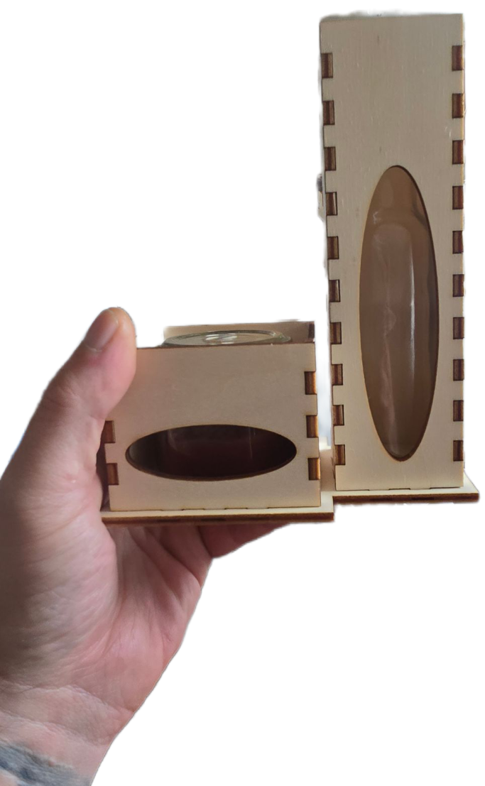 Maßgefertigte Holzboxen: Ein Set aus zwei unterschiedlich hohen Boxen mit präzisen Steckverbindungen und ovalem Sichtfenster.