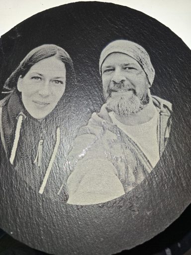Ergebnis der Fotogravur auf einer runden Schieferplatte. Personalisiertes Motiv als hochwertiges Unikat.